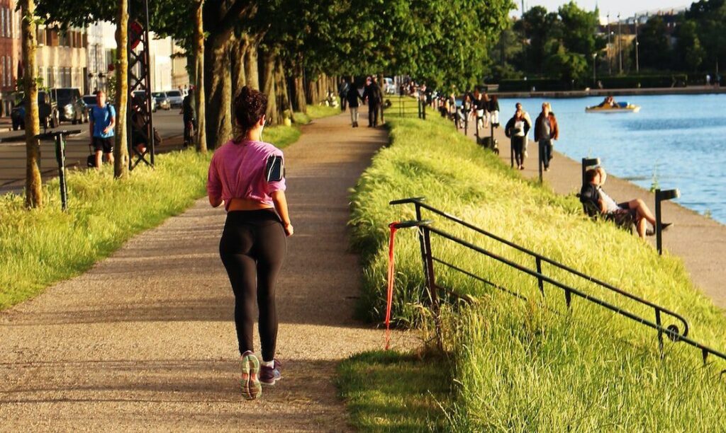 woman jogging near body of water