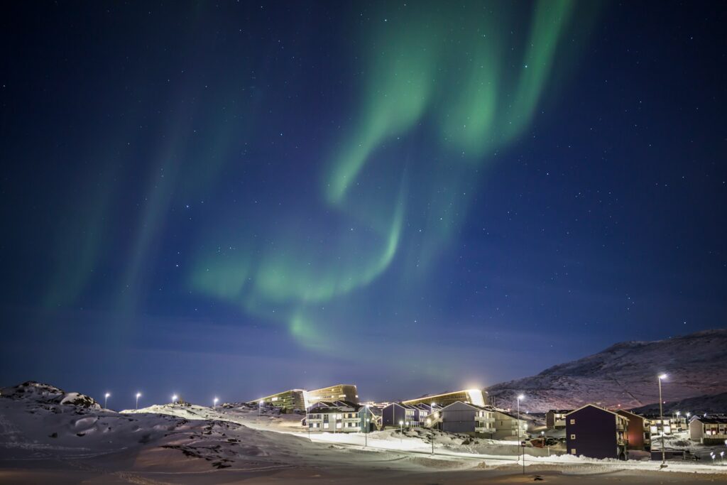 white and brown houses under green sky during night time